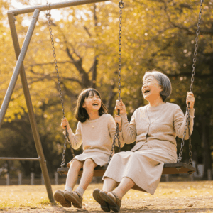 敬老の日の健康グッズ紹介記事用イメージ。おばあちゃんと孫娘が公園のブランコで笑顔を交わし、温かい時間を過ごしている様子。